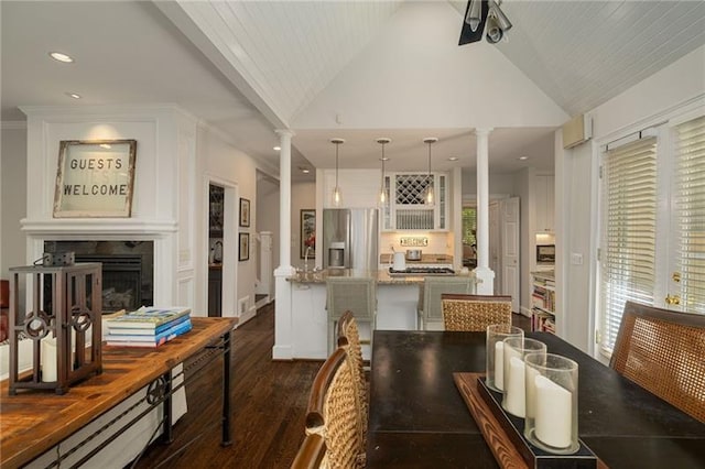 kitchen featuring ornate columns, a fireplace, a kitchen island, and stainless steel refrigerator with ice dispenser