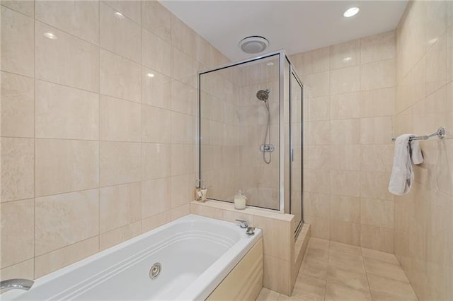 full bathroom featuring a bath, a shower stall, and tile walls