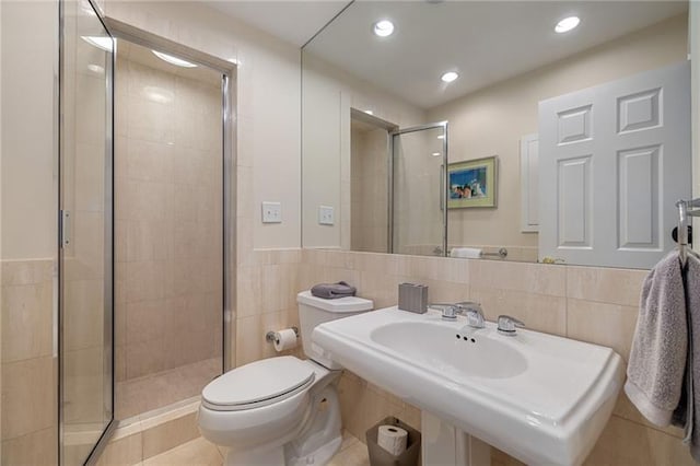 full bath with toilet, recessed lighting, a stall shower, tile walls, and a sink