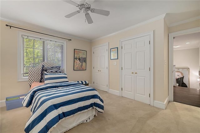 bedroom with baseboards, multiple closets, carpet, and ornamental molding