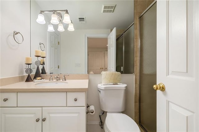 bathroom with visible vents, toilet, tiled shower, and vanity