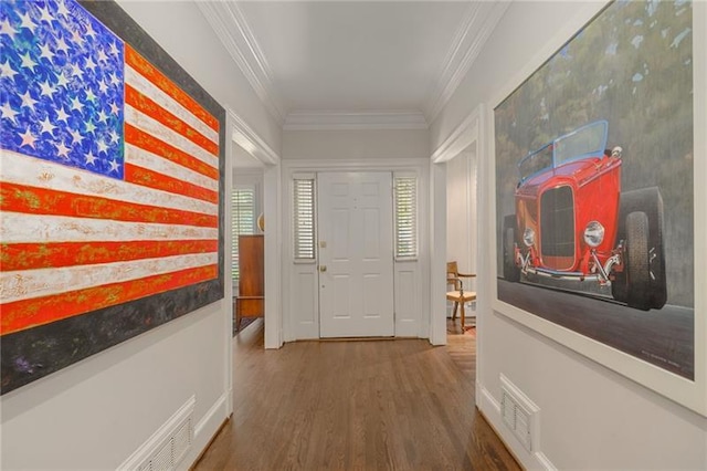 hallway featuring crown molding, wood finished floors, and visible vents