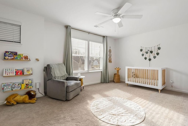 bedroom featuring a crib, carpet, and ceiling fan