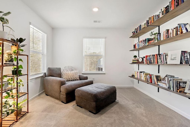 living area featuring light carpet