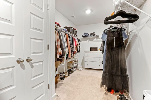 walk in closet featuring light colored carpet