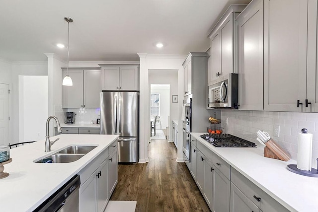 kitchen featuring sink, tasteful backsplash, appliances with stainless steel finishes, gray cabinets, and pendant lighting