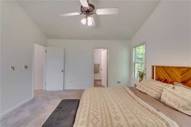 carpeted bedroom featuring ensuite bathroom, vaulted ceiling, and ceiling fan