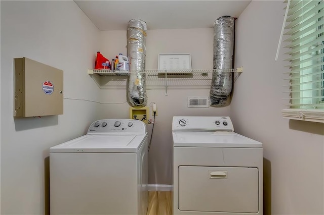 laundry room with independent washer and dryer and hardwood / wood-style flooring