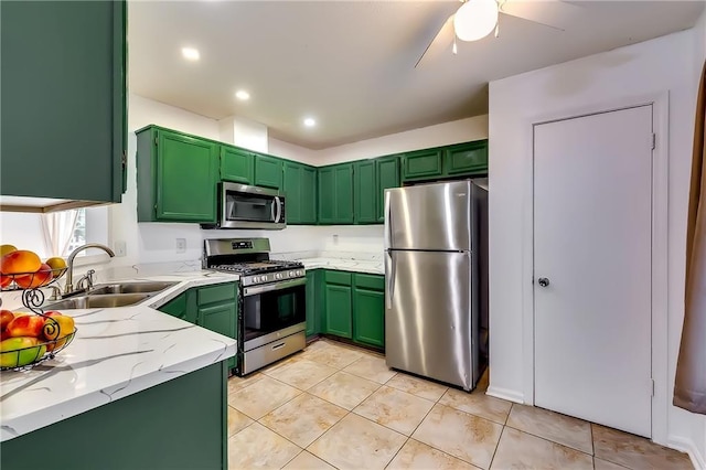 kitchen with sink, light stone counters, stainless steel appliances, and green cabinets