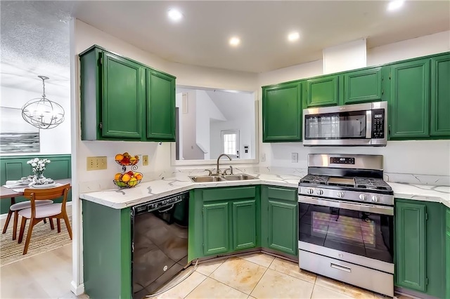 kitchen with appliances with stainless steel finishes, sink, green cabinetry, light tile patterned floors, and a chandelier