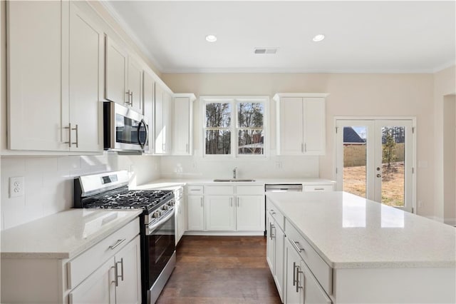 5997 Creek Indian Dr, Sugar Hill, GA 30518 - kitchen featuring appliances with stainless steel finishes, plenty of natural light, decorative backsplash, a kitchen island, and ornamental molding