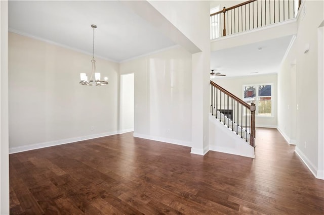 5997 Creek Indian Dr, Sugar Hill, GA 30518 - spare room featuring a chandelier, stairs, crown molding, dark wood-style flooring, and ceiling fan