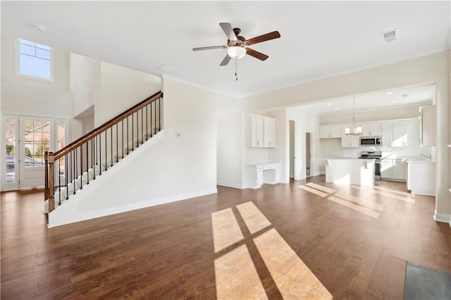 5997 Creek Indian Dr, Sugar Hill, GA 30518 - unfurnished living room with plenty of natural light, stairs, wood finished floors, a chandelier, and crown molding