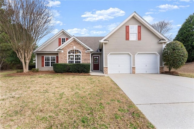 traditional-style home with a garage, stone siding, a front yard, and driveway