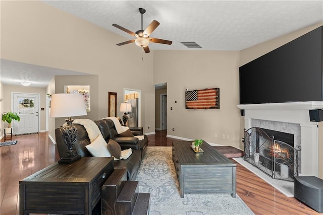 living area featuring visible vents, a textured ceiling, and ceiling fan