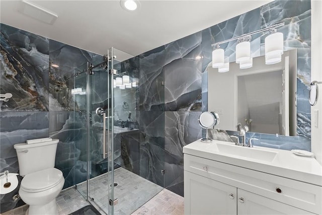 full bathroom with vanity, tile walls, toilet, and a marble finish shower