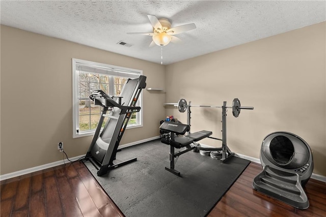 exercise area featuring visible vents, baseboards, a ceiling fan, and wood finished floors