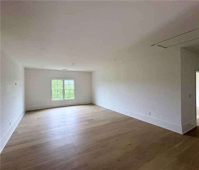 unfurnished room with wood finished floors and baseboards