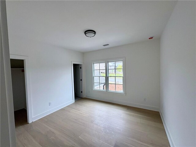 unfurnished bedroom featuring light wood-type flooring and baseboards