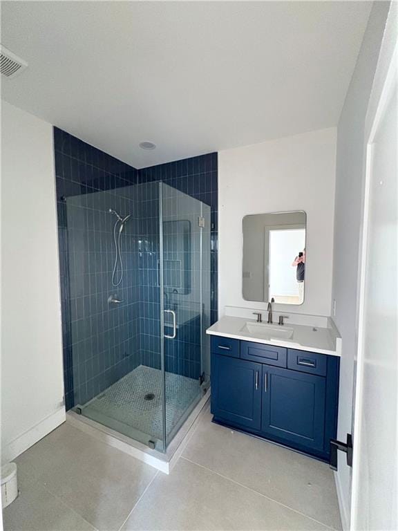 full bathroom with a stall shower, vanity, and tile patterned flooring