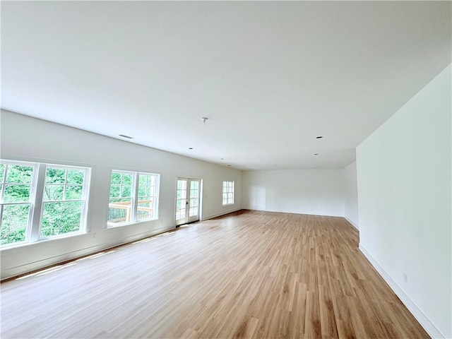 unfurnished living room featuring light wood-style flooring and baseboards