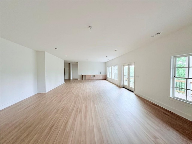 unfurnished living room featuring light wood-type flooring and baseboards