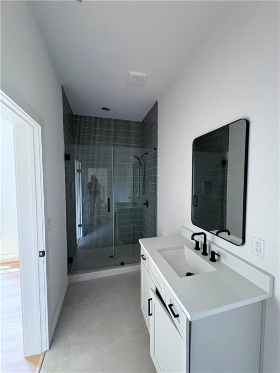 full bathroom with a shower stall and vanity