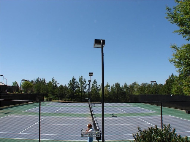 view of tennis court featuring fence