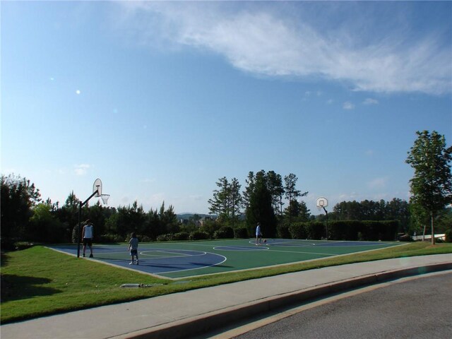 view of basketball court with community basketball court and a yard