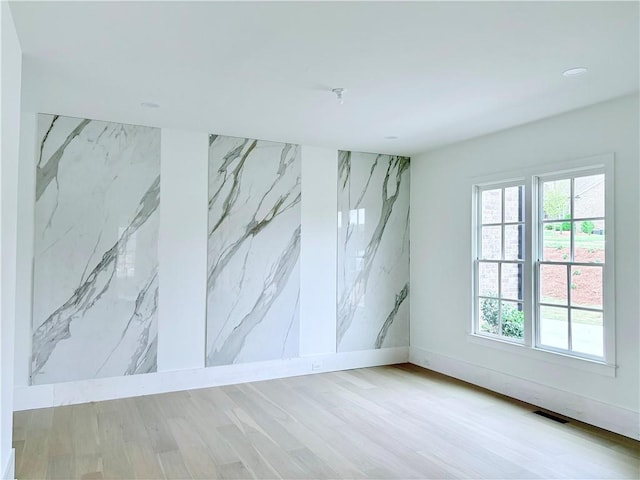 unfurnished room with healthy amount of natural light, wood finished floors, recessed lighting, and baseboards