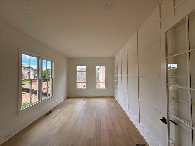 unfurnished room with baseboards and light wood-style flooring