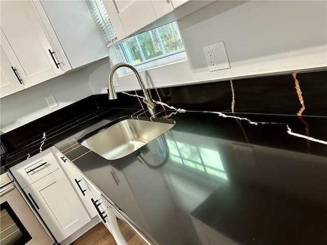 details with sink, white cabinets, and dark hardwood / wood-style floors