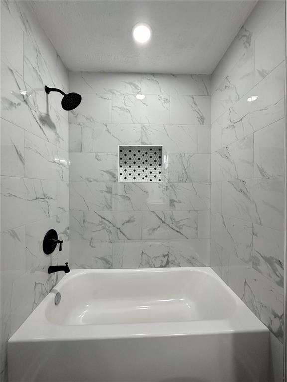 bathroom with tiled shower / bath combo