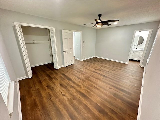 unfurnished bedroom with ensuite bathroom, dark hardwood / wood-style flooring, sink, and ceiling fan