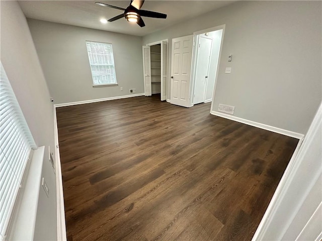 unfurnished bedroom with multiple windows, dark hardwood / wood-style flooring, and ceiling fan