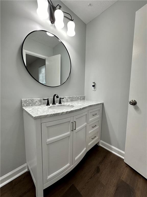 bathroom featuring vanity, hardwood / wood-style flooring, and a textured ceiling