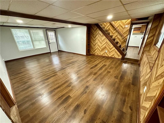 unfurnished room with dark wood-type flooring and a paneled ceiling