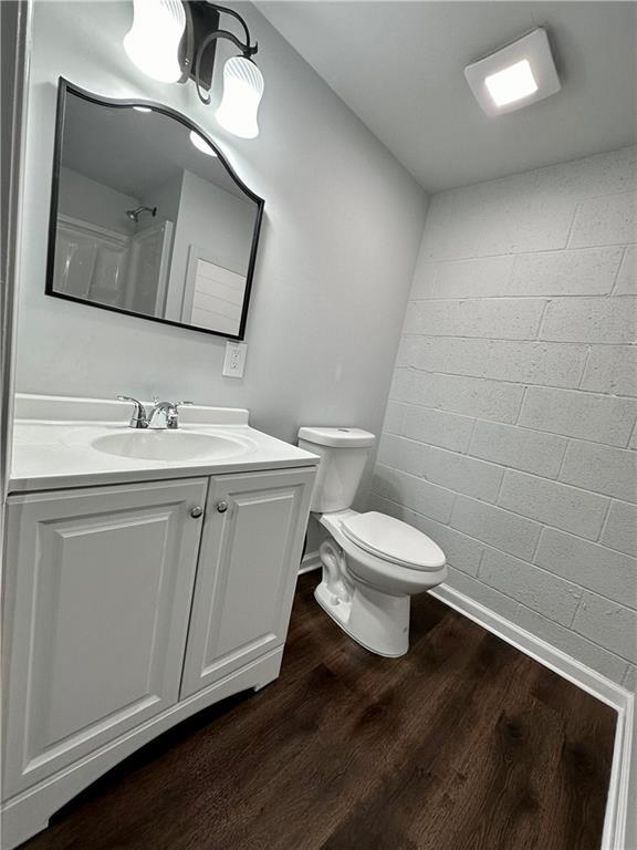 bathroom with hardwood / wood-style flooring, vanity, and toilet