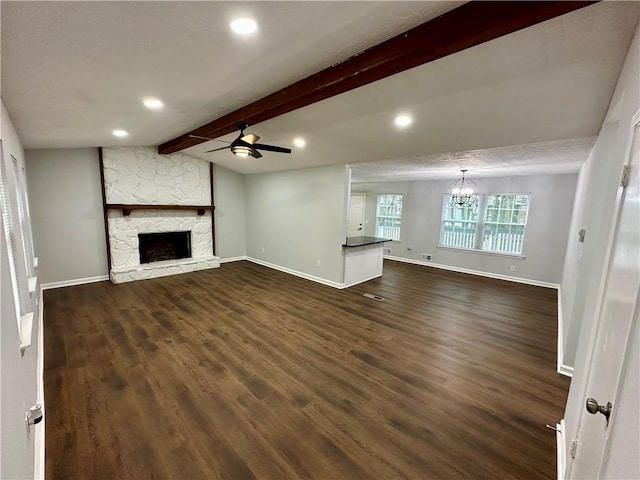 unfurnished living room with lofted ceiling with beams, ceiling fan with notable chandelier, a fireplace, and dark hardwood / wood-style flooring