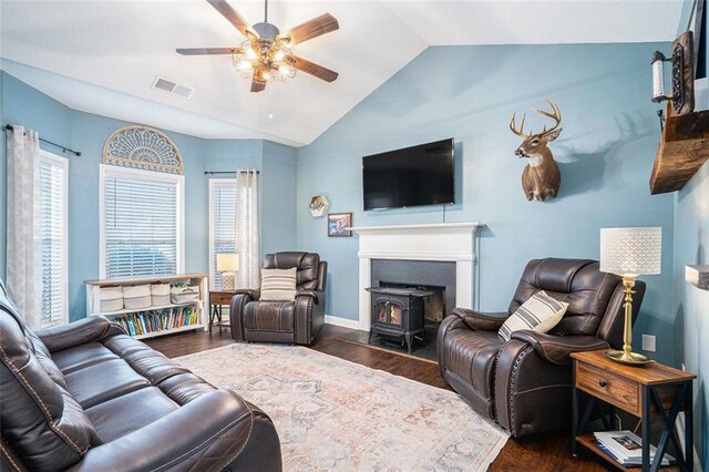 living room featuring dark hardwood / wood-style flooring, ceiling fan, and vaulted ceiling