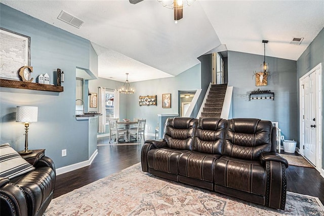 living room featuring ceiling fan with notable chandelier, vaulted ceiling, and dark hardwood / wood-style floors