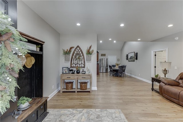 interior space with lofted ceiling and light hardwood / wood-style flooring