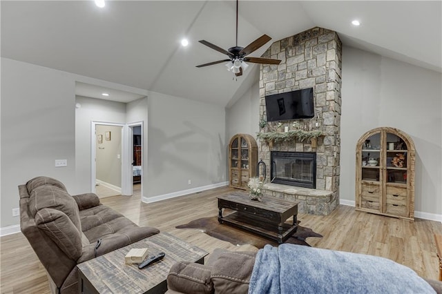 living room with a fireplace, high vaulted ceiling, and light hardwood / wood-style flooring