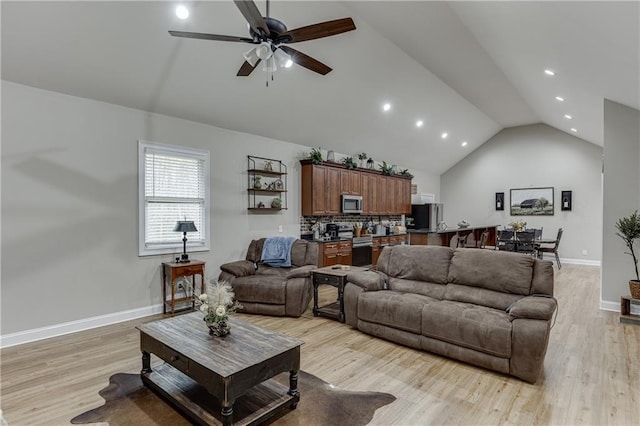 living room with high vaulted ceiling, light hardwood / wood-style floors, and ceiling fan