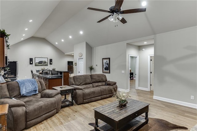 living room featuring ceiling fan, high vaulted ceiling, and light wood-type flooring