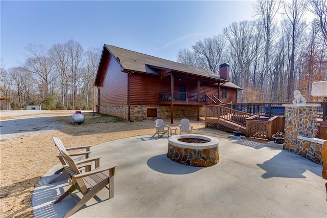 view of patio / terrace with a deck and an outdoor fire pit