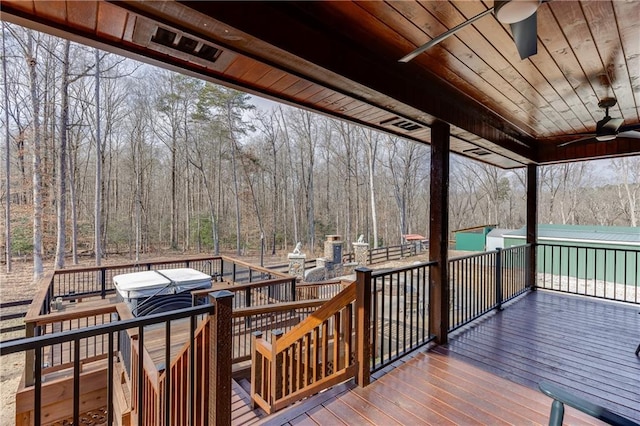 wooden deck with ceiling fan, a fireplace, and a jacuzzi