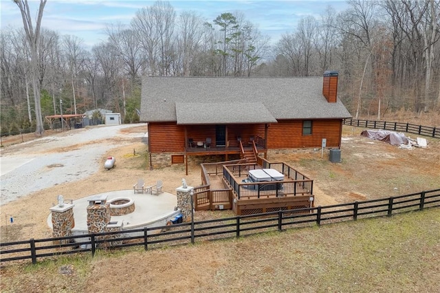 rear view of house featuring a wooden deck and a fire pit