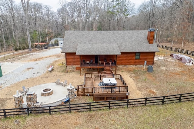 rear view of property with a wooden deck, central AC, and an outdoor fire pit