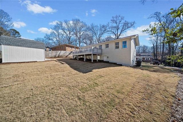 rear view of house with a wooden deck, a yard, and a shed